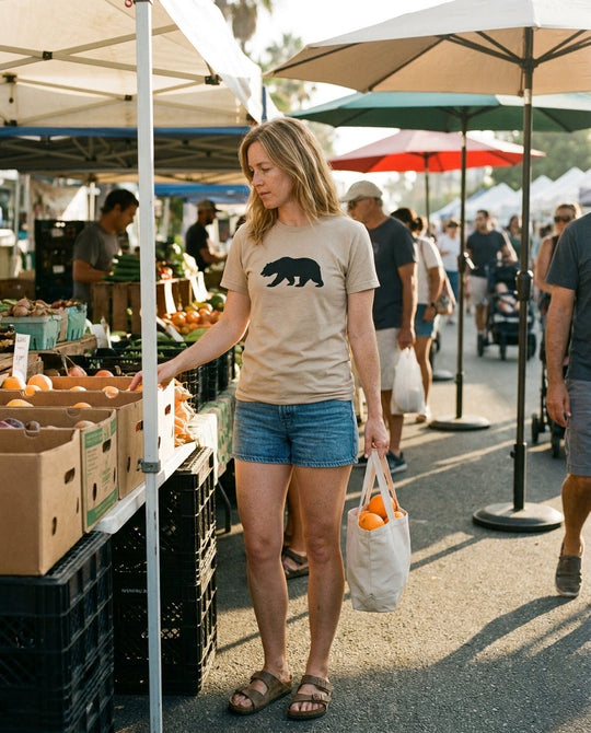 California Bear Tee styled with denim shorts at a Santa Monica farmers market, Bella+Canvas 3001 sand tan, Cali Life Co apparel.