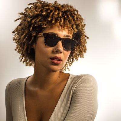 Eagle Peak polarized lens detail showing UV400 tint and optical clarity, plant-based acetate with wood-grain temples frame by Cali Life Co